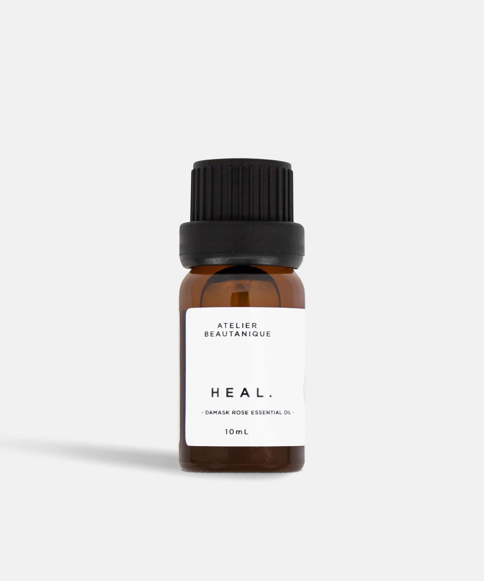 Atelier Beautanique HEAL. Rose Essential Oil 10mL Bottle on Grey Background with Light Shadow