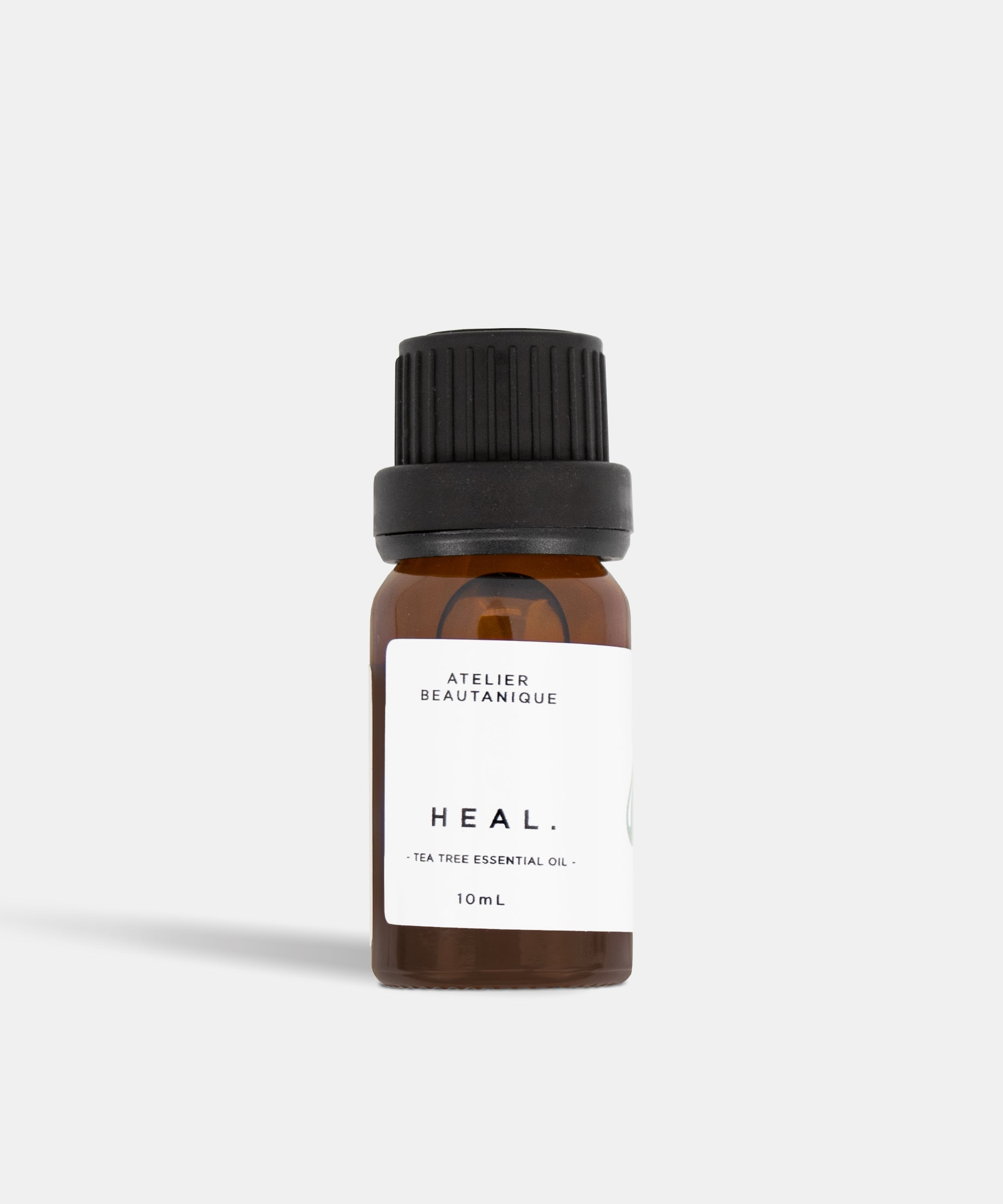 Atelier Beautanique HEAL. Tea Tree Essential Oil Bottle on Grey Background with Light Shadow