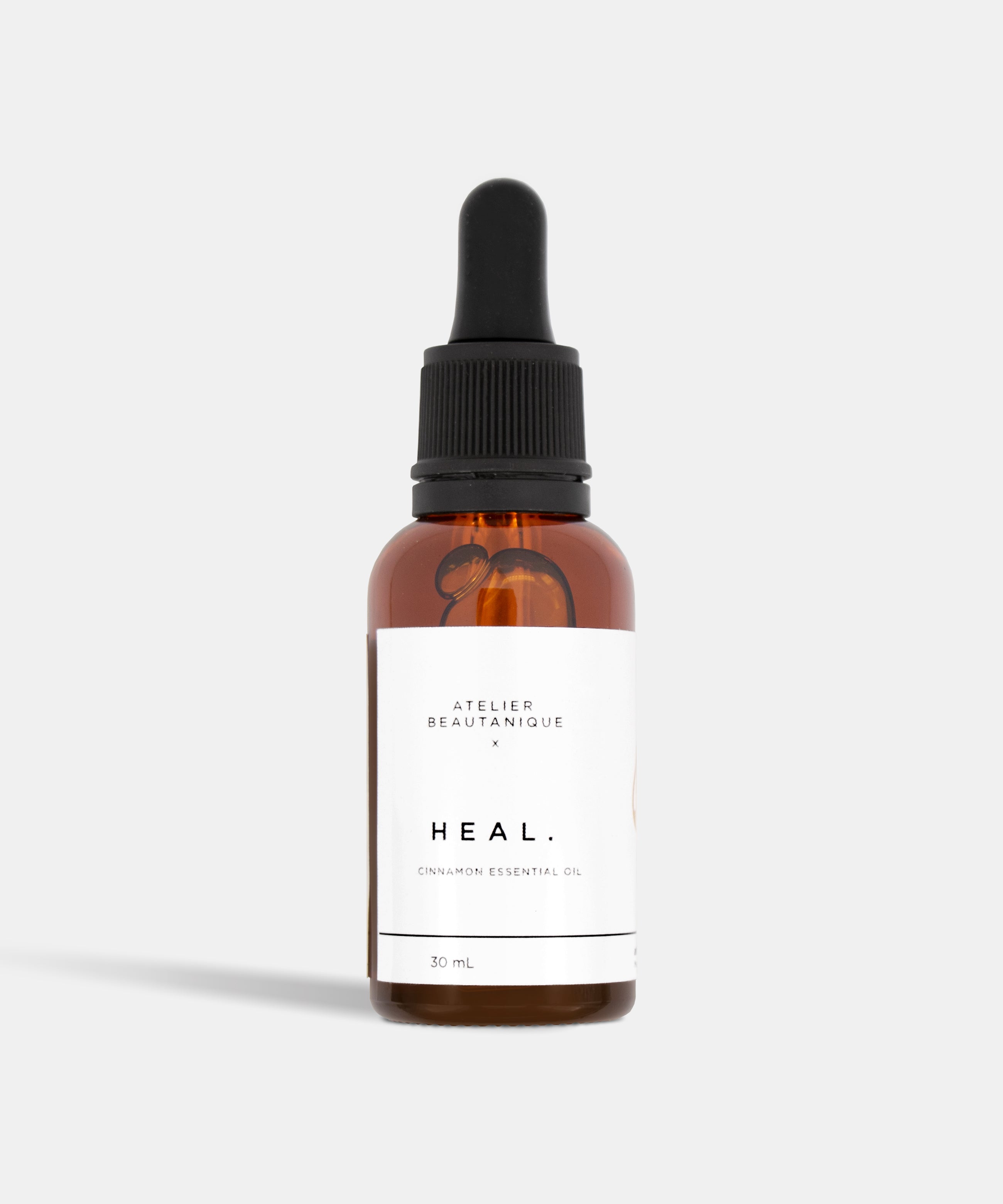 Atelier Beautanique HEAL. Cinnamon Essential Oil 10mL Bottle on Grey Background with Light Shadow