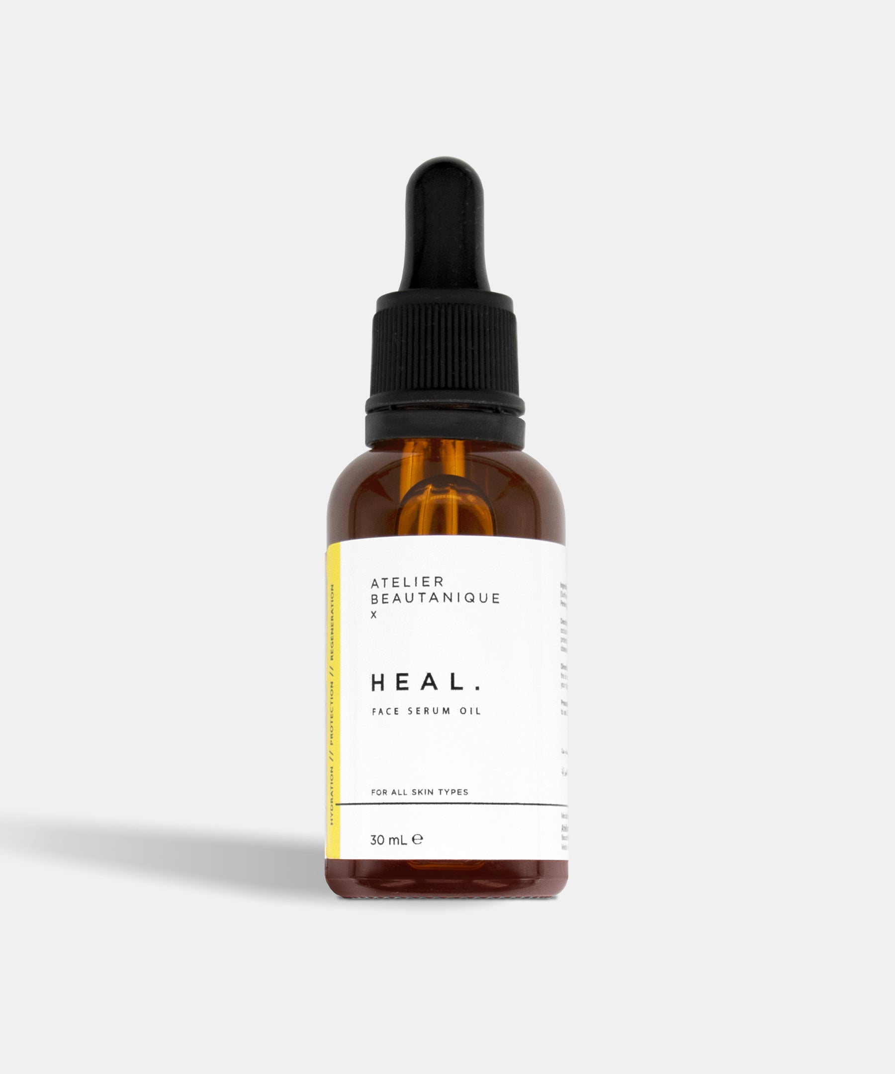 Atelier Beautanique HEAL. Face Serum Oil Bottle on Grey Background with Light Shadow