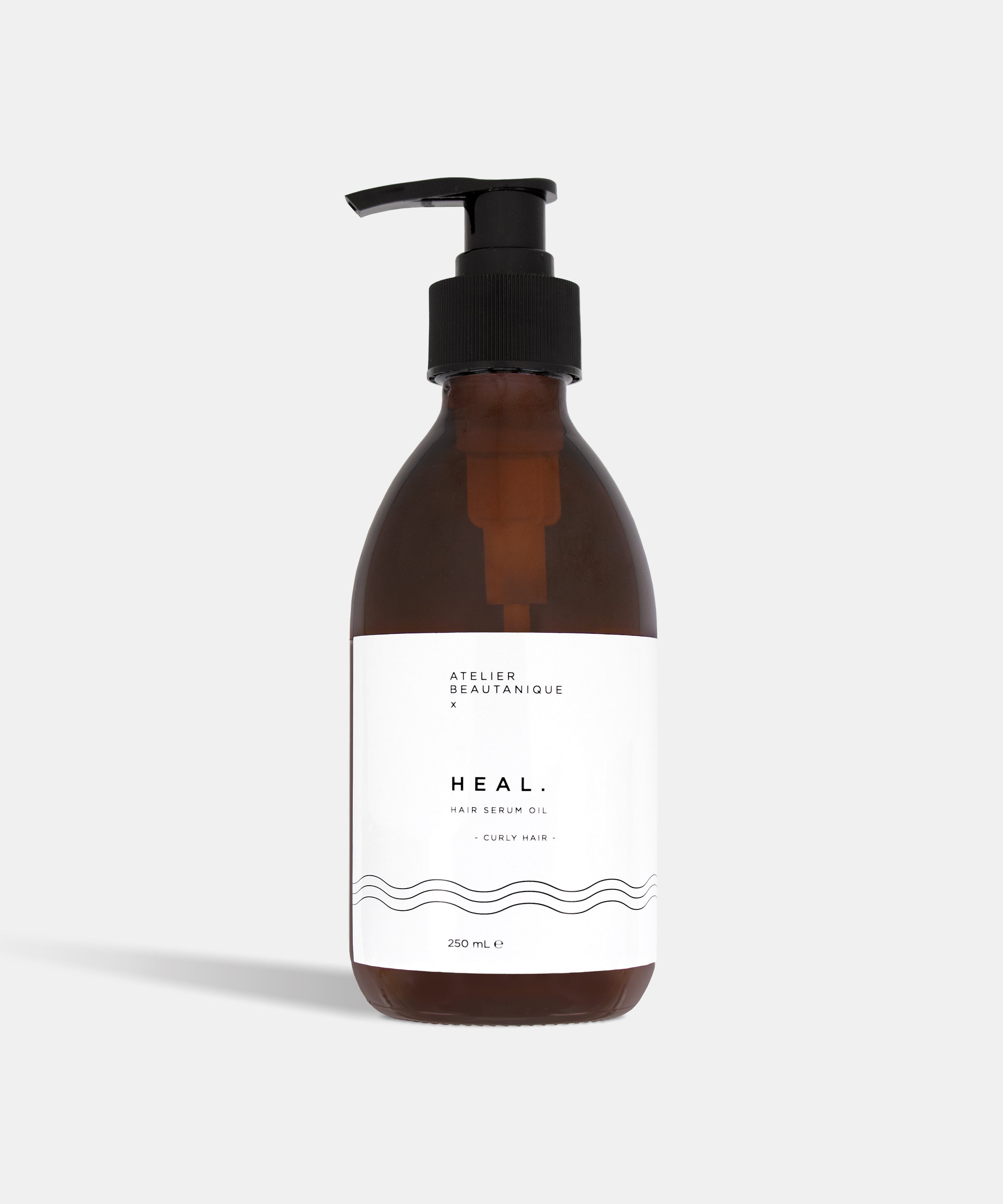 Atelier Beautanique HEAL. Curly Hair Hair Serum Oil Bottle on Grey Background with Light Shadow
