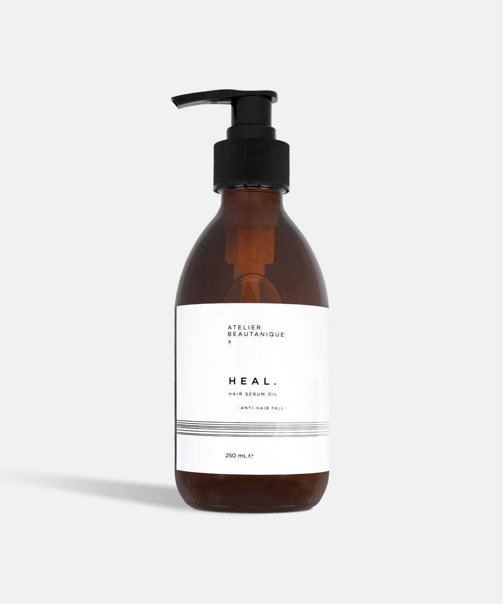Atelier Beautanique HEAL. Anti-Hair Fall Hair Serum Oil Bottle on Grey Background with Light Shadow