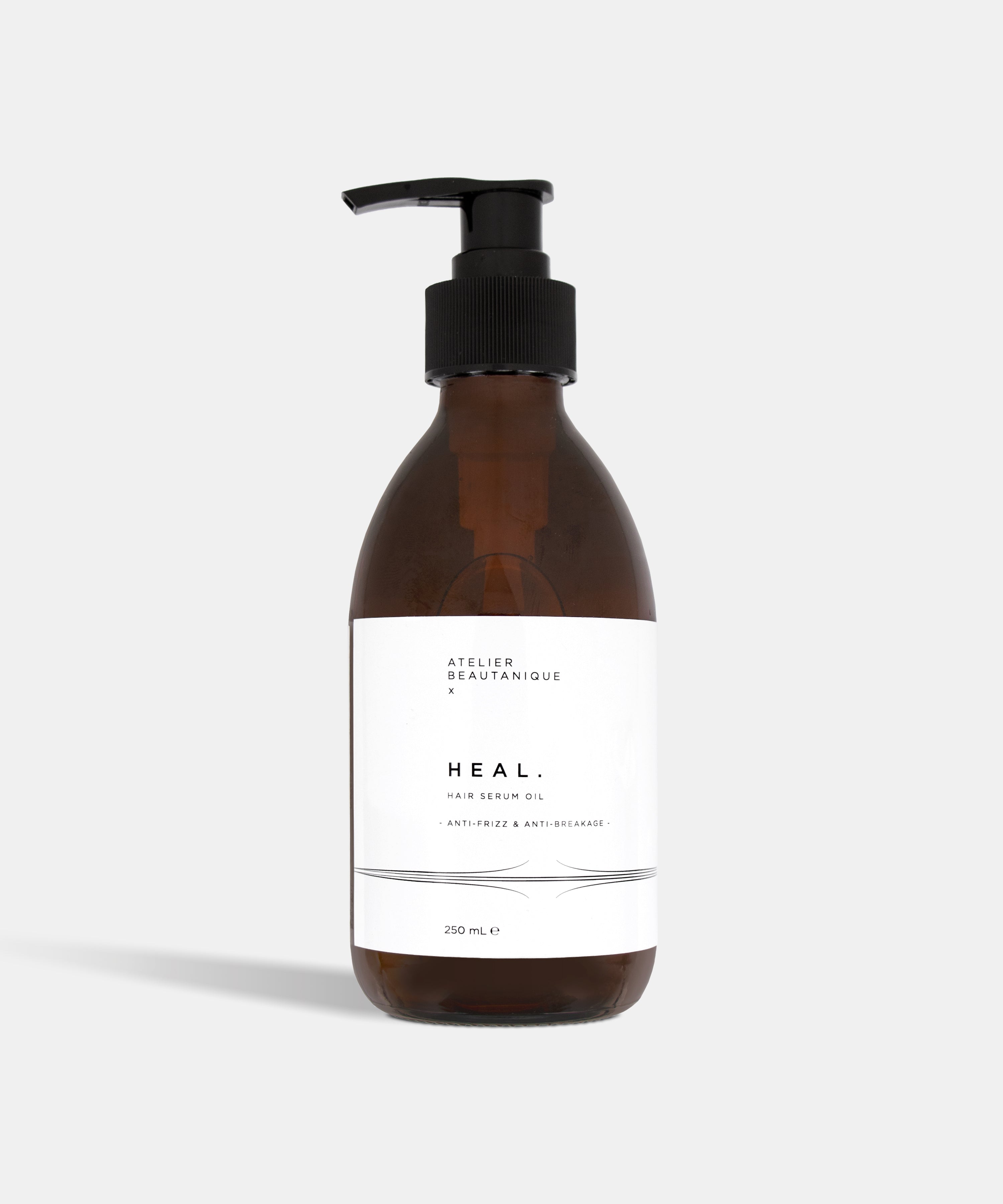 Atelier Beautanique HEAL. Anti-Frizz Hair Serum Oil Bottle on Grey Background with Light Shadow