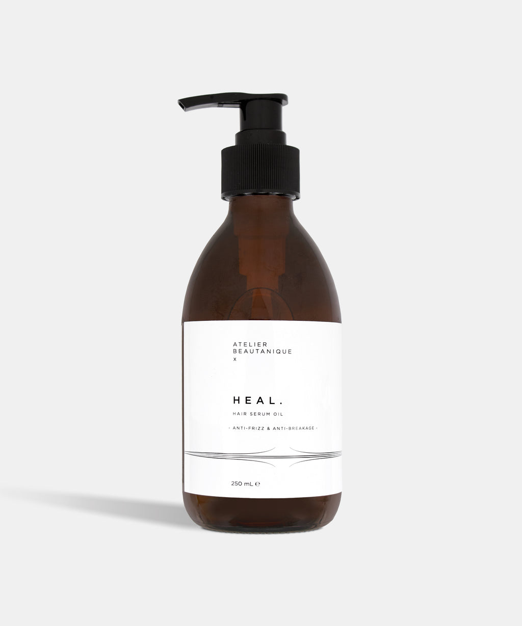 Atelier Beautanique HEAL. Anti-Frizz Hair Serum Oil Bottle on Grey Background with Light Shadow