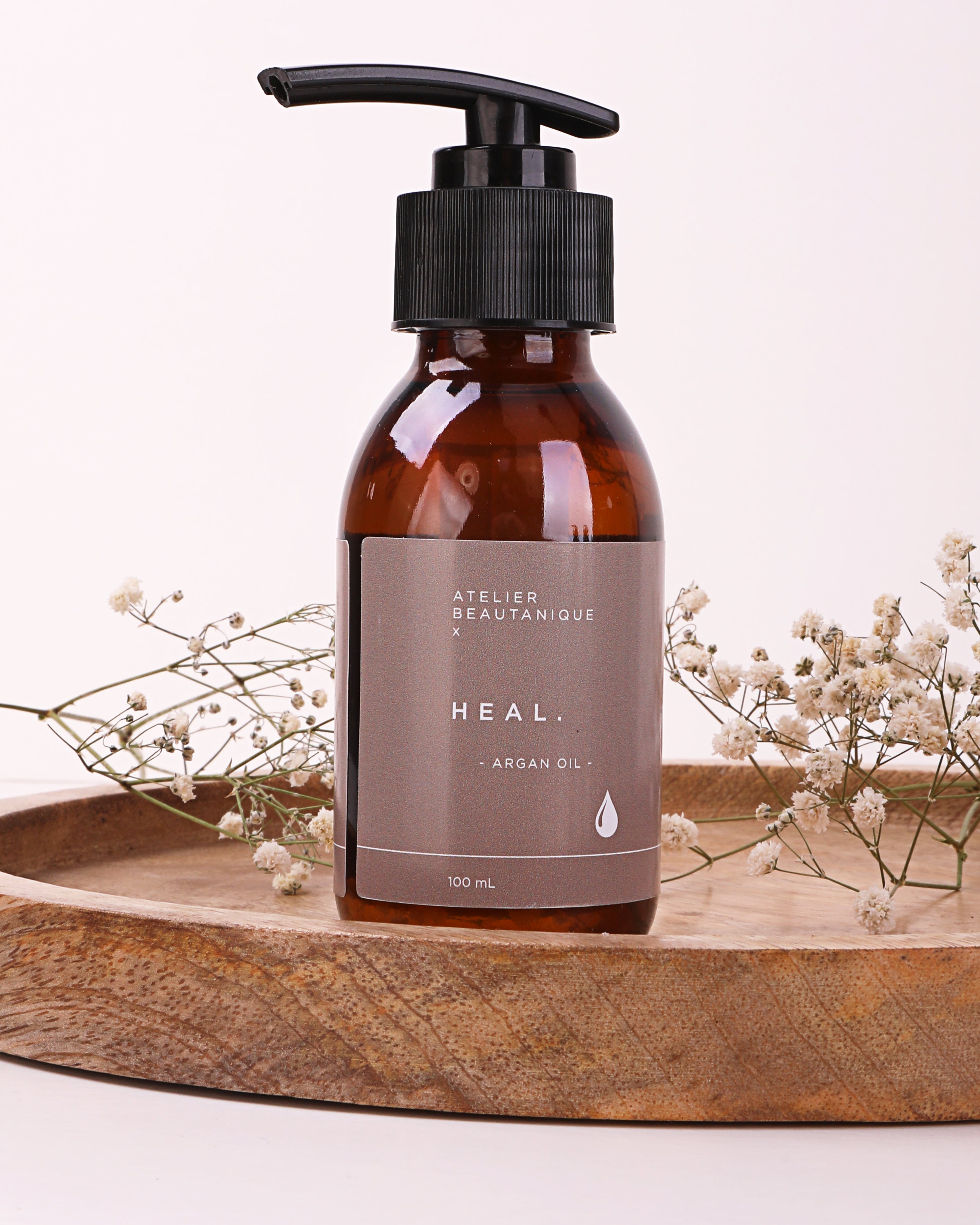 Atelier Beautanique HEAL. Argan Oil Bottle on Grey Background with Light Shadow