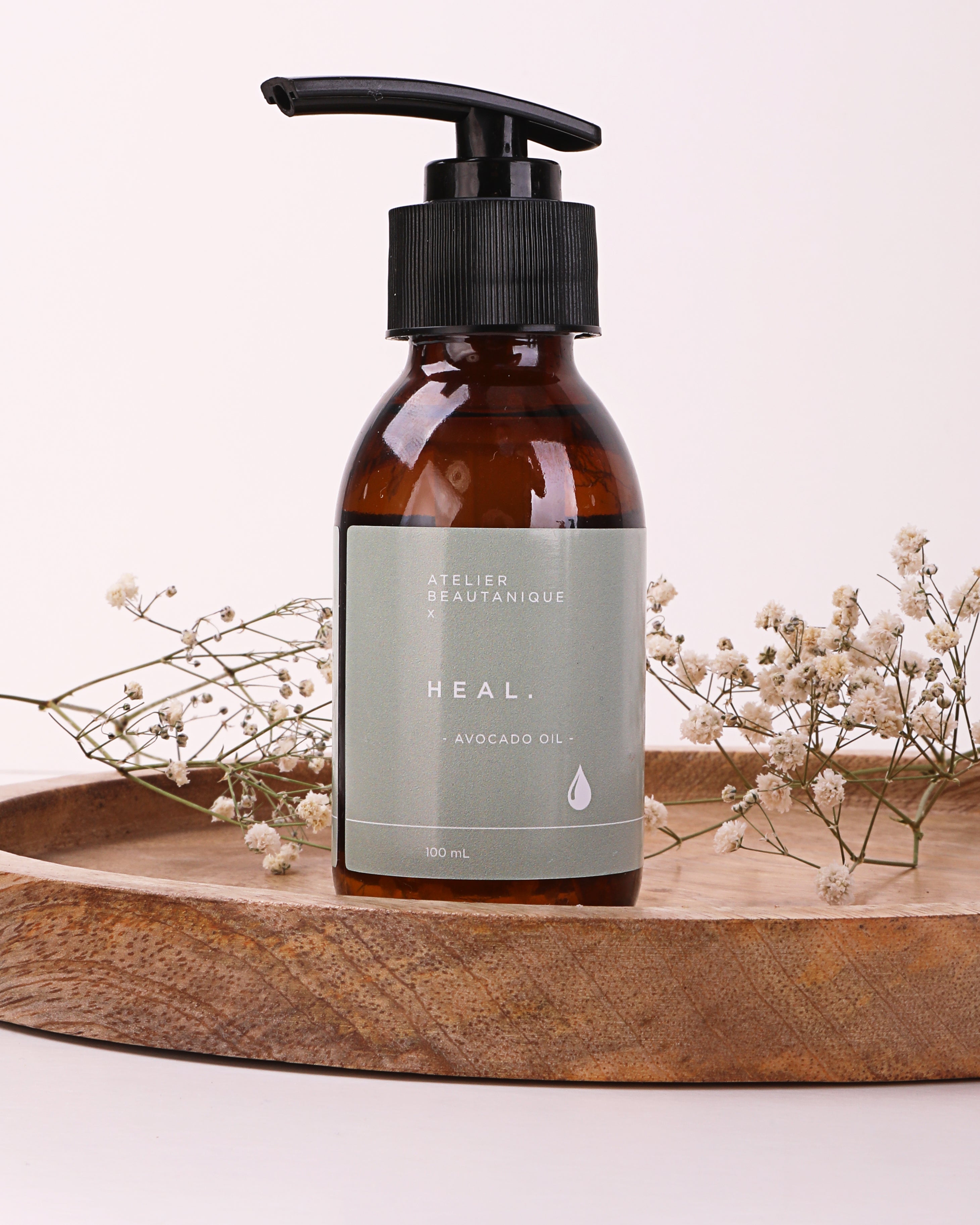 Atelier Beautanique HEAL. Avocado Oil Bottle on Grey Background with Light Shadow