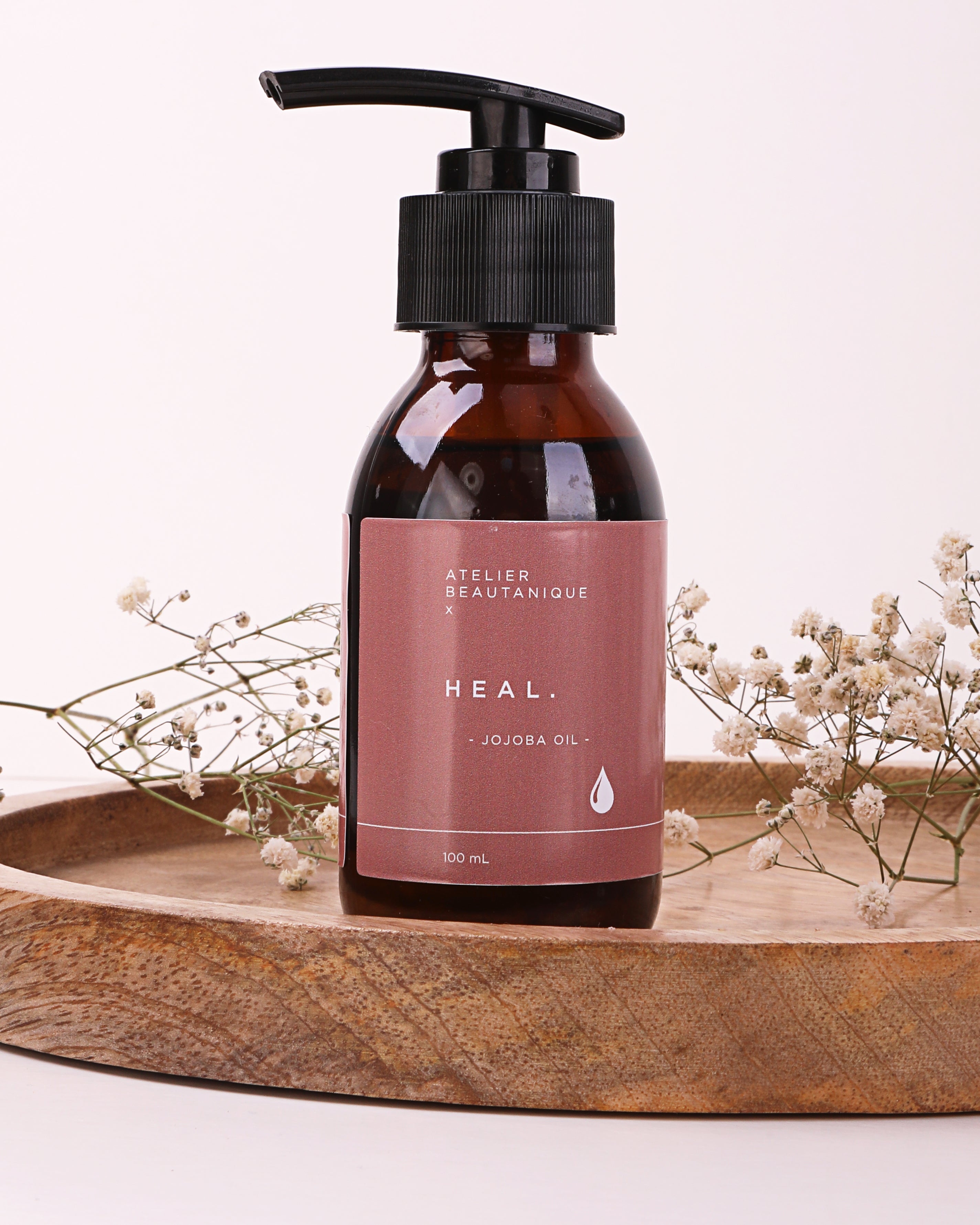 Atelier Beautanique HEAL. Jojoba Oil Bottle on Grey Background with Light Shadow
