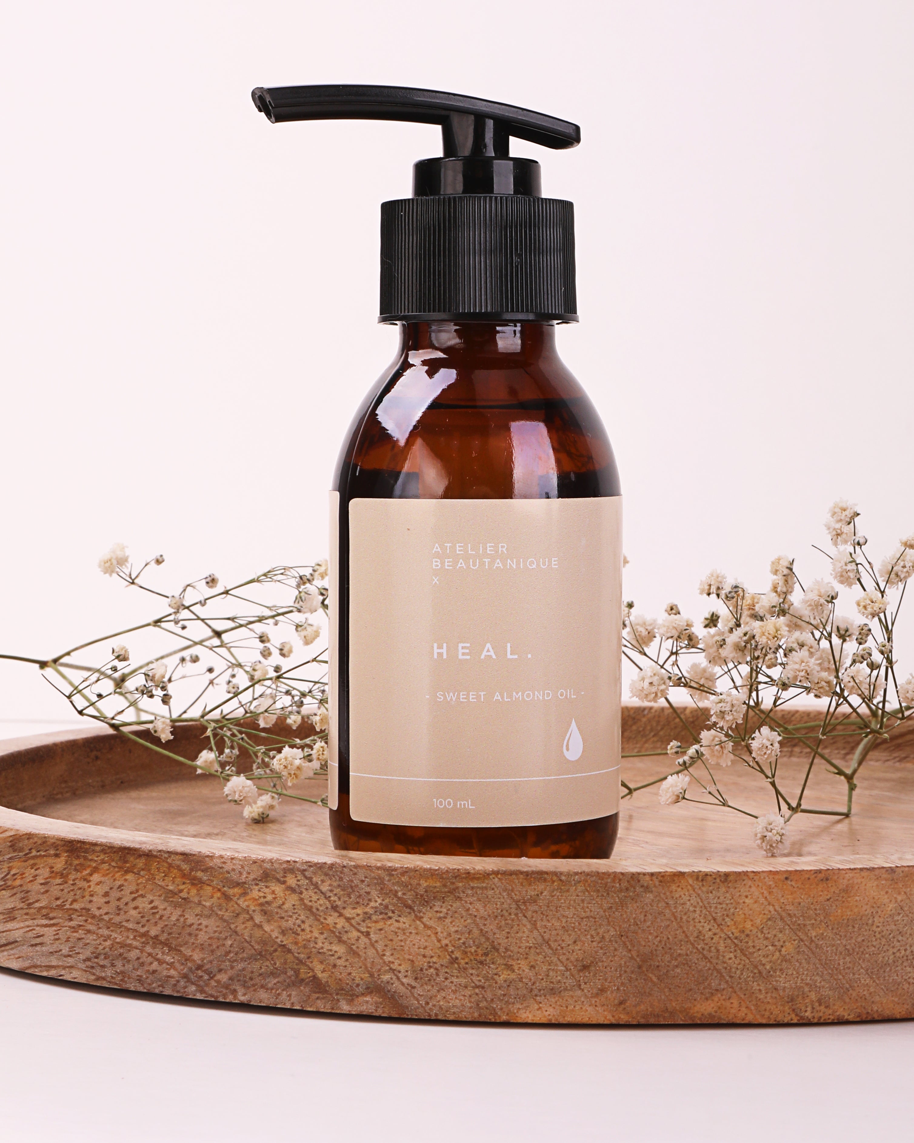 Atelier Beautanique HEAL. Sweet Almond Oil Bottle on Grey Background with Light Shadow